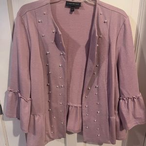 Pink jacket/sweater with white pearls.